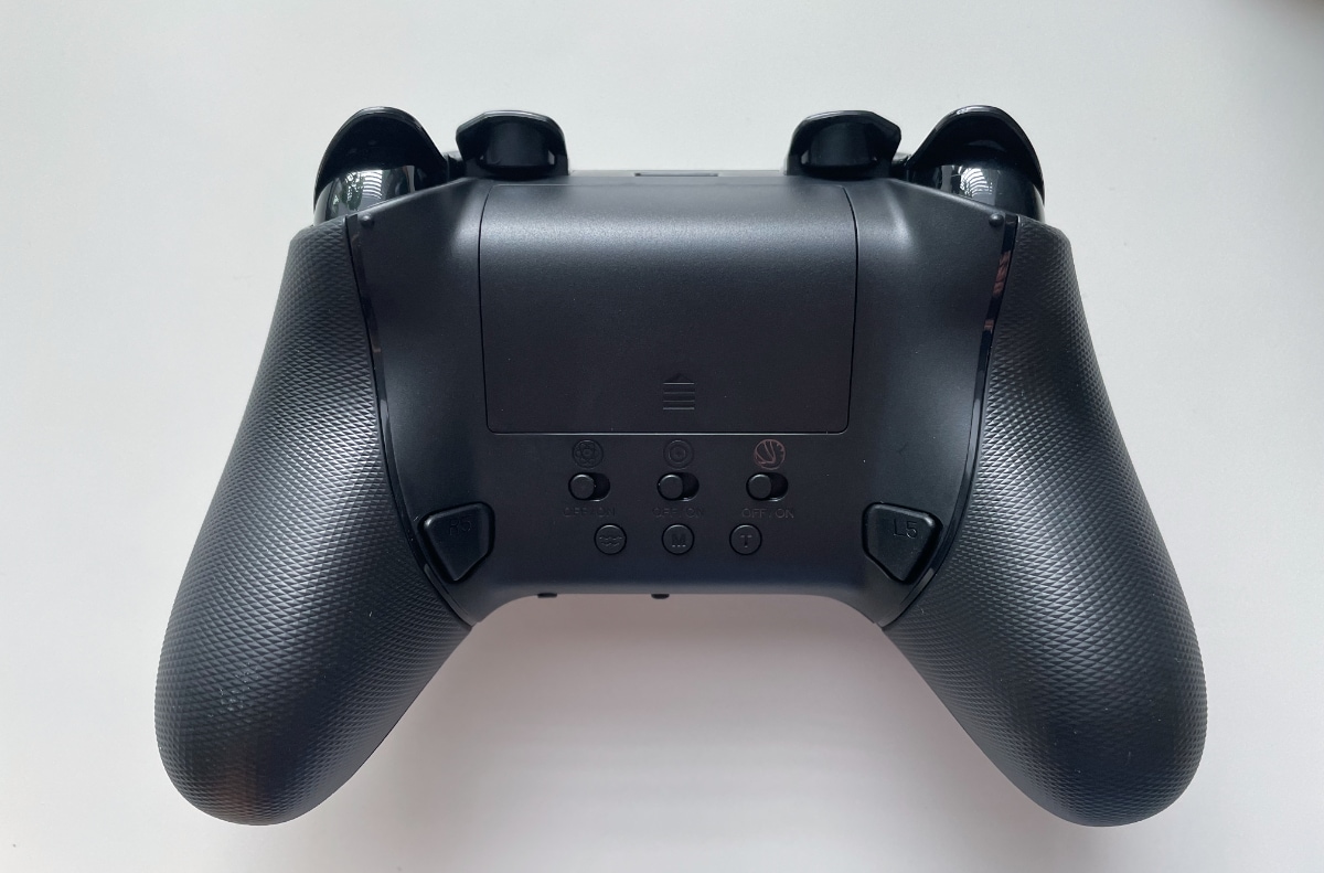 A black gaming controller with various buttons on a white background.