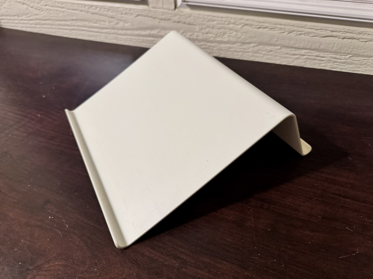White plastic laptop stand placed on a wooden desk
