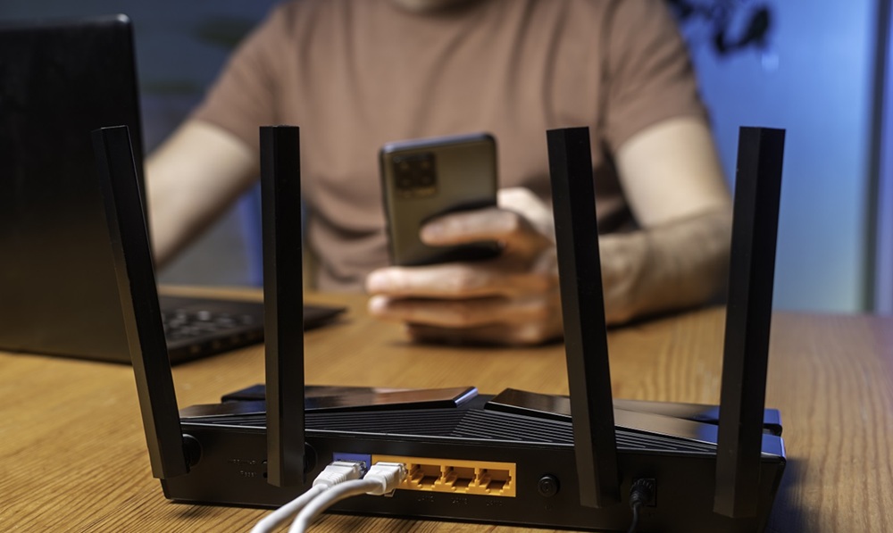 Modern WiFi router with multiple antennas on wooden desk Modern WiFi router with multiple antennas on wooden desk