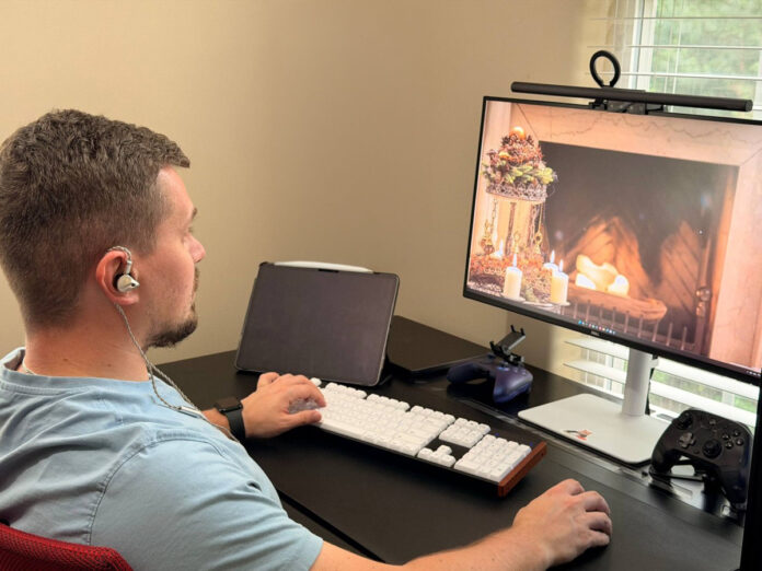 Person wearing ATK Horizon gaming earbuds while using a desktop computer. Person wearing ATK Horizon gaming earbuds while using a desktop computer.