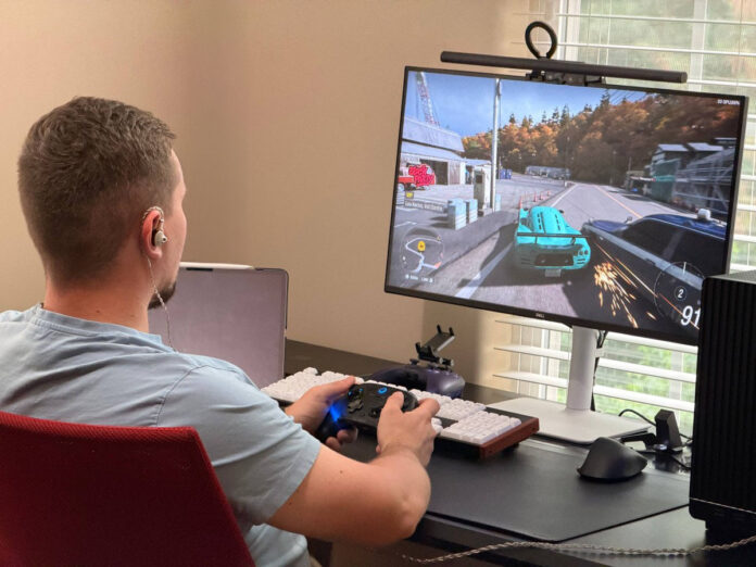 User wearing ATK Horizon earphones while playing a racing game with a controller. User wearing ATK Horizon earphones while playing a racing game with a controller.