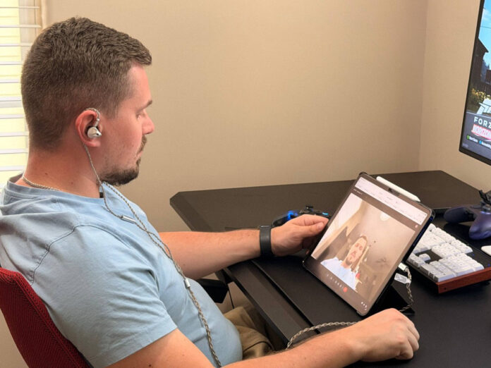 User wearing ATK Horizon earphones during a video call on a tablet. User wearing ATK Horizon earphones during a video call on a tablet.