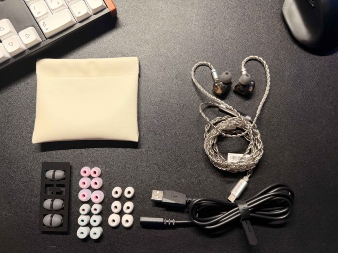 ATK Horizon gaming earbuds with included accessories, ear tips, carrying pouch, and USB cable laid out on a desk. ATK Horizon gaming earbuds with included accessories, ear tips, carrying pouch, and USB cable laid out on a desk.