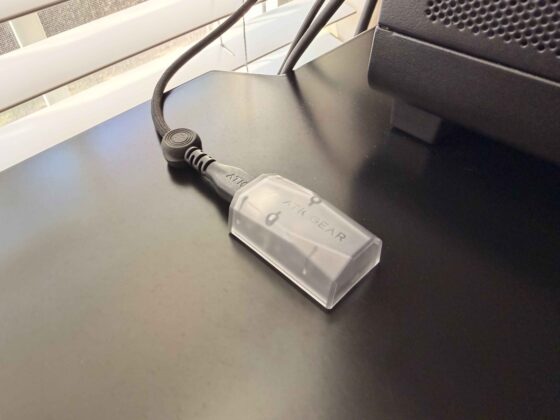 ATK Gear 8K wireless receiver connected to a USB cable beside a desktop PC.