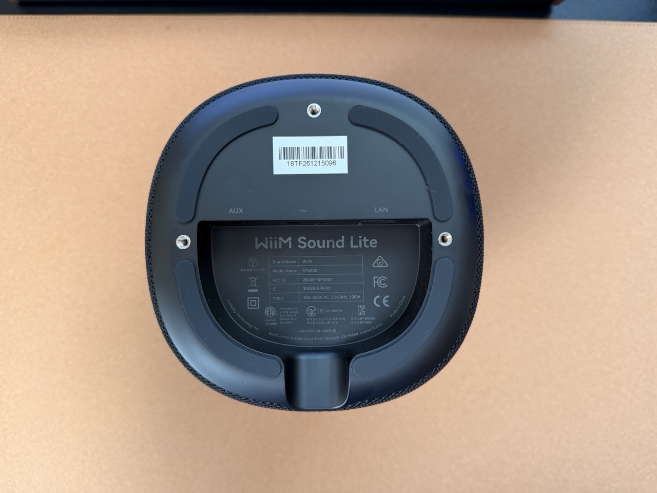 Bottom view of the WiiM Sound Lite showing the integrated power input, LAN port, rubber feet, and product information label Bottom view of the WiiM Sound Lite showing the integrated power input, LAN port, rubber feet, and product information label.