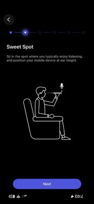 WiiM Home app RoomFit setup instructing the user to hold the phone at ear height in the listening position.